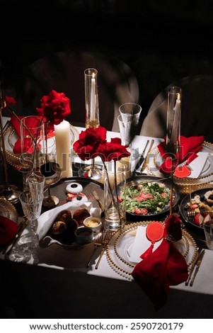 Luxurious table setting with red and gold decor, featuring elegant crystal glasses, candles, and floral arrangements. A sophisticated and festive atmosphere perfect for weddings, gala dinners, or roma