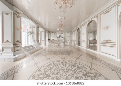 Luxurious vintage interior with fireplace in the aristocratic style. Large Windows and mirrors. Columns and arches, ornament on the glossy floor - Shutterstock ID 1063868822