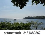 a luxurious yacht in the middle of the cove of Nasugbu bay surrounded by houses on the cliff