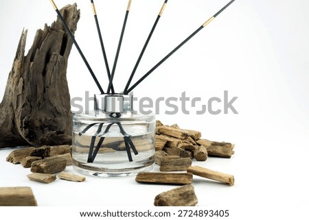 luxury aroma scented reed diffuser glass bottle with black sticks on white table with oud wood or agarwood in nice living room which can create cozy relax aroma ambient scent in from room freshener