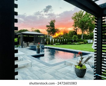 Luxury backyard that's spa like and tranquil. Pool, fire pit, pergola, pavilion, bar, lounge, outdoor furniture, dining set, rug, patio and hot tub.  Surrounded by a lush garden amid the summer sunset - Powered by Shutterstock