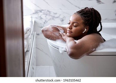 Luxury bath african woman relaxing in hotel spa bathtub or home bathroom for total relaxation