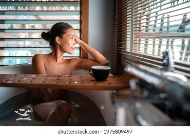 Luxury Bath Asian Woman Relaxing In Warm Water Enjoying View From Bathroom Window Lying In Bathtub With Bath Wooden Board Caddy Drinking Coffee Cup.