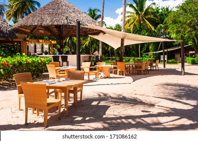 Luxury beach resort on Caribbean sea in Dominican Republic, cozy cafe on white sandy coast, beautiful big palm trees, enjoying day spa, summer holidays concept