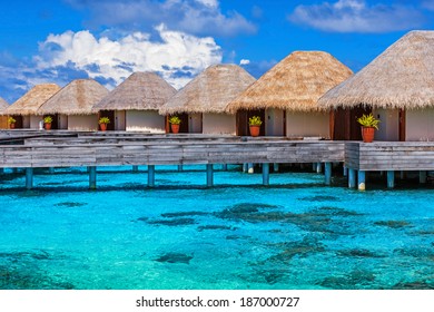 Luxury beach resort on Maldives, many cute bungalows standing on transparent water, Indian ocean, romantic place for honeymoon, summer vacation concept
