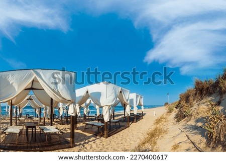 Luxury beach tents canopies on morning paradise white sandy beach (Pescoluse, Salento, Puglia, south Italy). The most beautiful sea sandy beach of Apulia.