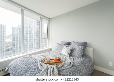 Luxury Bedroom. Contemporary Design With Reclaimed Wood Bedside Tables And Lamp. Nice And Cozy Accommodations. Hotel Or Resort Room. Vancouver Downtown View.