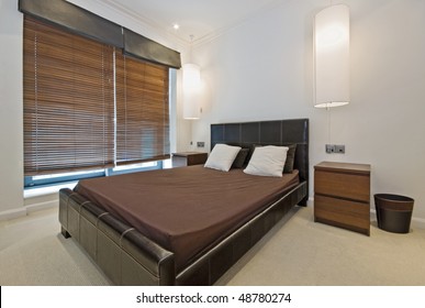 luxury bedroom with hanging lamp shades and vertical blinds