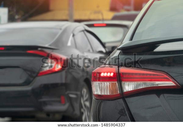 Luxury of black car stop on the road with\
many car in traffic jam, Open brake\
light.