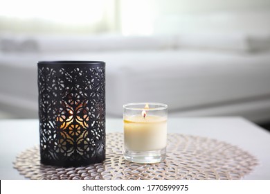 The Luxury Black Metal Candle Holder Is Displayed On The Grey Table With The Lighting Aroma Scent Candle In The White Bedroom Near Sunlight From The Curtain Window