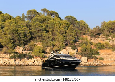 Luxury Black Motor Yacht Moored Near Island. Black Yacht At Sunset