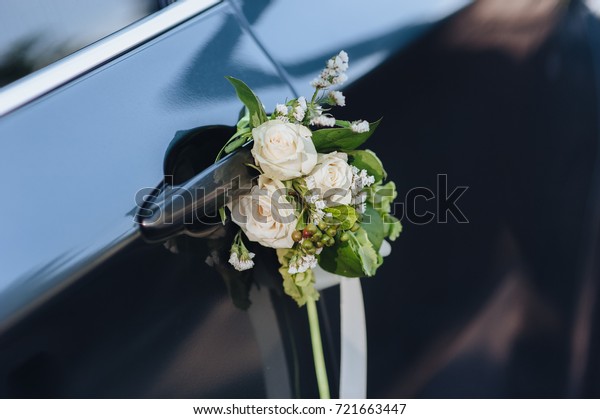Luxury black\
wedding car decorated with\
flowers.