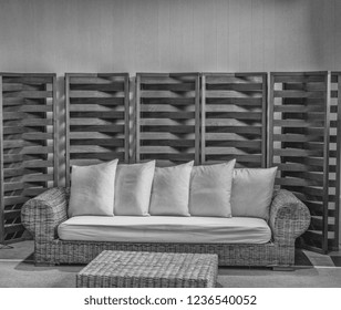 Luxury Black And White Patio Furniture Display With Teak Lattice Backdrop.