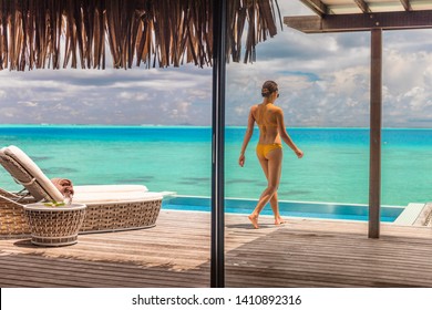 Luxury Bora Bora Resort Hotel Woman Walking On Her Private Terrace Deck Of Overwater Bungalow Villa With Infinity Pool View On Turquoise Ocean - Honeymoon's Suite.