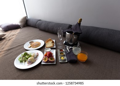 A Luxury Breakfast With Champagne, Fruit, Fruit Juice, Pancakes, Toast And Eggs Benedict. 