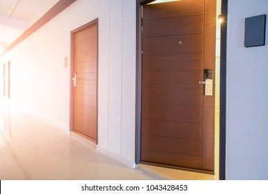 Luxury brown wooden door with electronic lock and viewer in hotel corridor