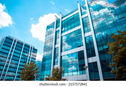 Luxury Building Exterior With Sky Reflection On Glass Windows. Blue Modern Business City Center Architecture. Corporate Urban Buildings Background