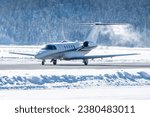 Luxury business jet taking off in engadin valley in the Swiss alps. The airport of Samedan is used by wealthy people to get to their ski vacations in winter. This airplane did no de-icing before dep.