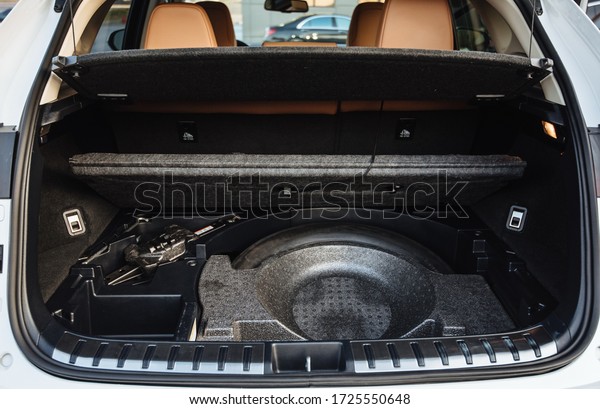 Luxury\
car boot with folded seats. Opened empty car trunk. Clean trunk of\
the SUV. Spare wheel in the trunk of a modern\
car