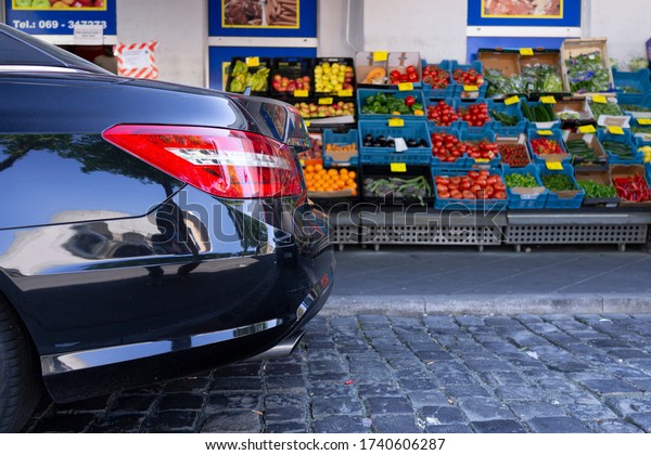 a luxury car in\
front of a grocery store