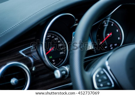 Luxury car interior details. Speedometer and steering wheel