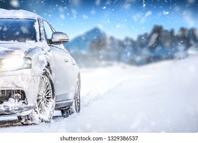 Luxury Car On Winter Road, Blur Mountains Background. Tires At Snow Highway.