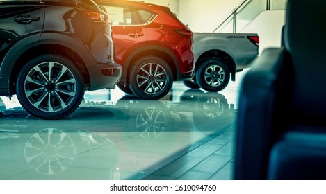 Luxury car parked in modern showroom. Auto leasing business. Car dealership concept. Closeup wheel of red shiny car show in showroom. Automotive industry. Auto glass coating and shinning business.