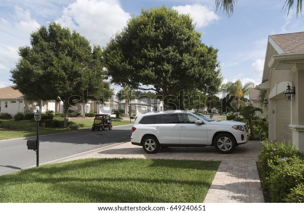 Luxury car parked on the driveway of a\
house in a Florida residential area, USA\
2017