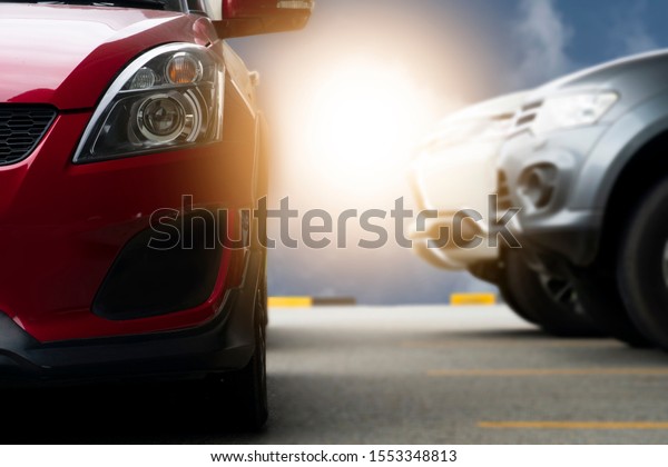 Luxury cars stop in parking lot with blurred\
two car backside.