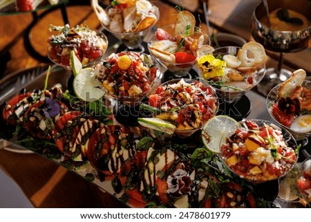 Luxury catering seafood snacks with shrimp, ceviche, and lime slices drizzled with balsamic glaze