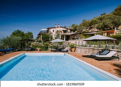 Luxury Country House With Swimming Pool In Italy. Pool And Old Farm House During Sunset Central Italy. Couple On Vacation At Luxury Villa In Italy, Men And Woman Watching Sunset