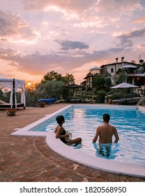 Luxury Country House With Swimming Pool In Italy. Pool And Old Farm House During Sunset Central Italy. Couple On Vacation At Luxury Villa In Italy, Men And Woman Watching Sunset