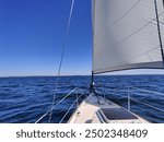 Luxury cruise on a sailing rigged yacht under a genoa and mainsail sailing in a light wind during the regatta. Yachting as a luxury sport and great vacation