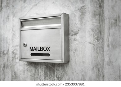 A luxury design stainless mailbox or postbox which is installed on concrete wall. Object for building decoration, close-up.