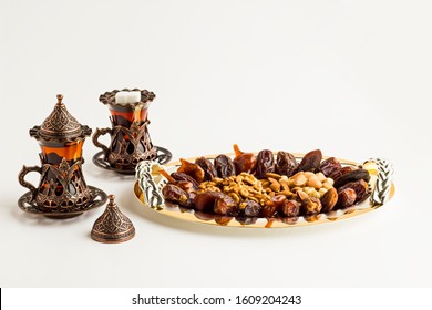 Luxuriöse Dry Date Früchte, Walnuss, Pistachio, Haselnüsse und Mandeln in der stilvollen, goldenen Schale mit Tee.Konzeptuelles Bild der islamischen Tradition Ramadan.