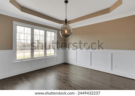 Luxury Empty Modern Dining Area with Beautiful Dark Floors and Unique Ceiling Trim
