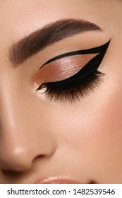 luxury female make-up close-up with eyeliner and golden eye shadow, glamourous cat eye mua, evening style
