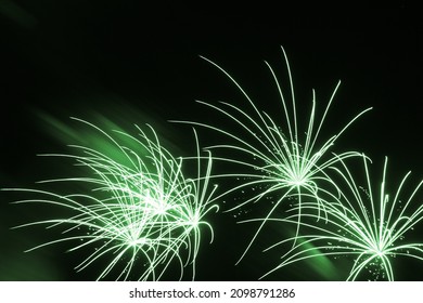 Luxury fireworks event sky show with beautiful fine green stars. Premium entertainment magic star firework at e.g. New Years Eve or Independence Day party celebration. Black dark night background