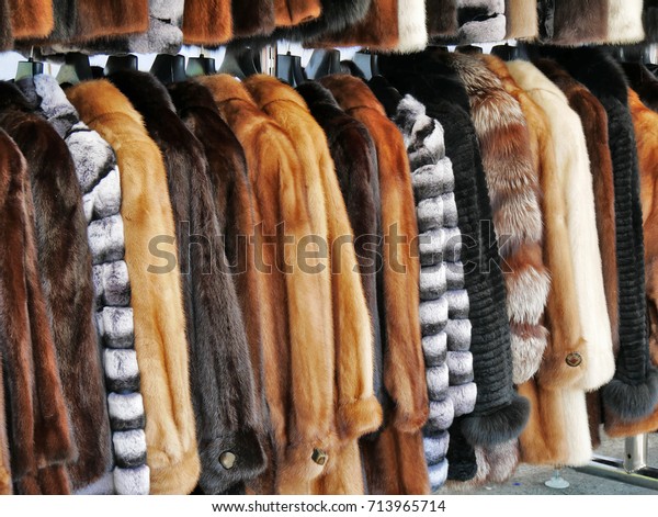 Luxury fur coats hanging on rack,\
various colors of mink, fox and sheep fur at the\
market