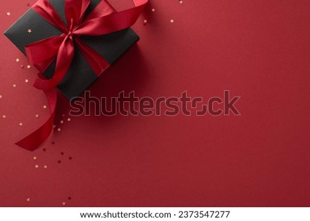 Luxury gifting: A top-view shot of a sophisticated black gift box adorned with a red ribbon, set amidst golden star-shaped confetti on a marsala background, with room for your custom text