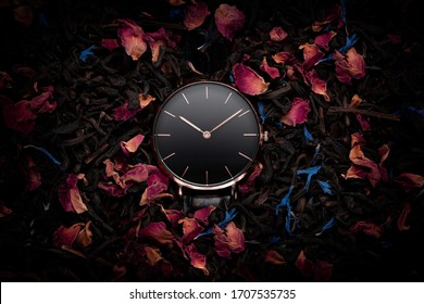 A luxury gold watch with a black dial. A watch on a beautiful stand, on a beautiful background of dried flowers, dried rose, colorful flowers. Woman / Man fashion
 - Shutterstock ID 1707535735