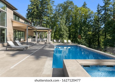 Luxury Home Exterior And Pool On Sunny Day With Blue Sky