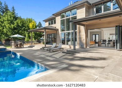 Luxury Home Exterior And Pool On Sunny Day With Blue Sky