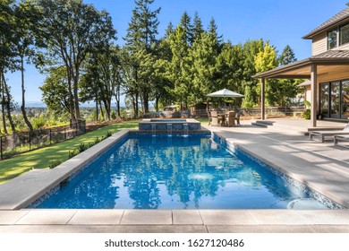 Luxury Home Exterior And Pool On Sunny Day With Blue Sky