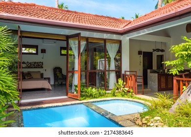 Luxury home with pool in backyard. Summer vacation house in Indian or Caribbean style and garden in courtyard. Nice villa on tropical beach, doors and interior of bungalow. Sri Lanka - Nov 4, 2017
