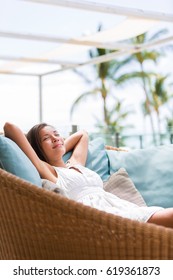 Luxury Hotel Lifestyle Woman Relaxing Sleeping Enjoying Luxury Sofa On Outdoor Patio Living Room. Happy Lady Lying Down On Comfortable Pillows Taking A Nap For Wellness And Health.