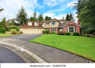 Luxury House Exterior With Brick Trim, Tile Roof And French Windows. House With Three Car Garage And Asphalt Driveway