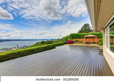 Luxury house exterior with large wooden walkout deck and blue sky background. Northwest, USA