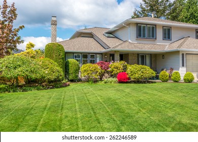 Luxury house with freshly mown grass lawn. Home exterior.