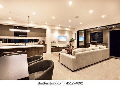 Luxury house interior with living room and the kitchen with tables, chairs, sofas with the flashing lights at night